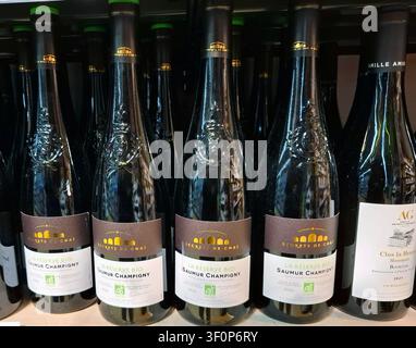 JUVISY, FRANKREICH - 27. September 2025. Flaschen von Saumur Champigny sind ordentlich in den Regalen eines Supermarkts in Frankreich angeordnet und präsentieren ihren Glanz Stockfoto