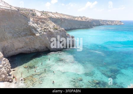Touristen genießen das Schwimmen im kristallklaren türkisfarbenen Wasser am schönen Strand von Tsigrado auf Milos. Stockfoto