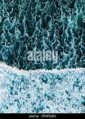 Luftaufnahme von tiefblauen Meereswellen mit weißem Seegras, das in Mauritius gegen die Oberfläche schlägt. Stockfoto