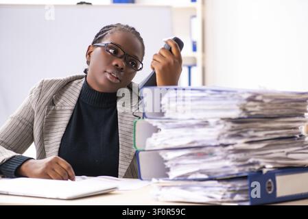 Schwarze weibliche Mitarbeiter mit übermäßiger Arbeit unzufrieden Stockfoto