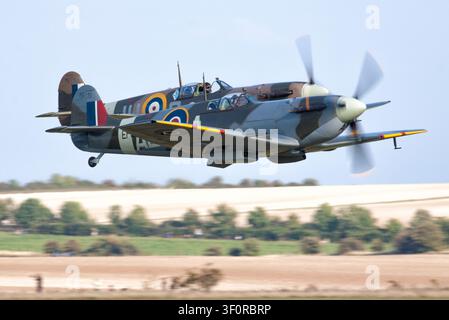 Zwei Supermarine Spitfires in enger Formation, tief über dem Land, präsentieren die klassische Eleganz und Kraft der RAF im Zweiten Weltkrieg. Stockfoto
