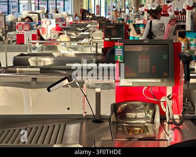 Leere Supermarkt-Kassenbereiche mit Kasse, Barcodescanner und Förderbändern im Auchan-Laden, Einzelhandelsinnenraum während der ruhigen Stunde, Einkaufen s Stockfoto