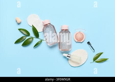 Natürliche Kosmetikprodukte und Make-up-Accessoires mit grünen Blättern auf einem hellblauen Hintergrund, Ansicht von oben Stockfoto
