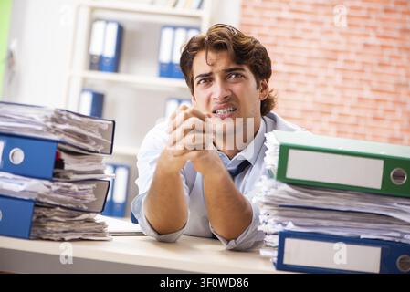 Junge elegante Mann mit zu viel Arbeit unzufrieden Stockfoto