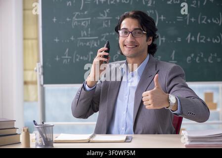 Junge schöne Mathematik Lehrer im Klassenzimmer Stockfoto
