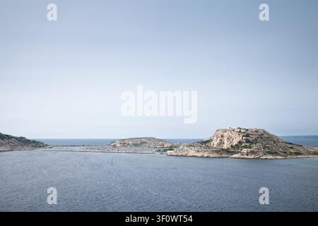 Panoramablick auf Port Frioul auf Ile Ratonneau in den Iles du Frioul, mit Marinawasser, felsiger Küste, Inselbefestigungen und dem Mittelmeer Stockfoto