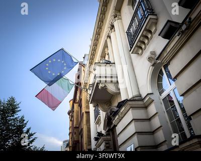 Italienische und Europäische Union-Flaggen auf einer Straße, die Einheit und Erbe durch historische Architektur symbolisieren. Italien ist ein Gründungsmitglied der EU und ein lea Stockfoto