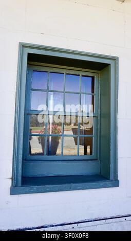 Historisches blaues Holzfenster mit weißer Stuckwand Stockfoto