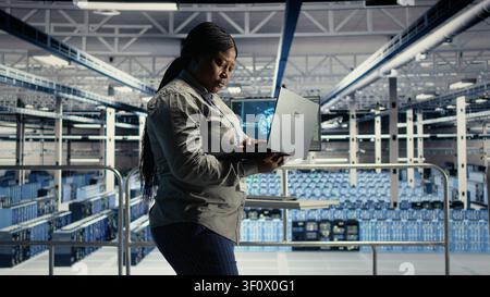 Der Administrator des Rechenzentrums verwendet einen Laptop, um Deep Learning-Prozesse zu überwachen und mit KI-Technologie und Hochleistungssystemen zu arbeiten. Stockfoto