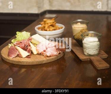 Handwerkliche Schanktafel mit gepökeltem Fleisch, Käse und hausgemachten Aufstrichen Stockfoto