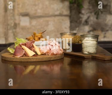 Handwerkliche Schanktafel mit gepökeltem Fleisch, Käse und hausgemachten Aufstrichen Stockfoto
