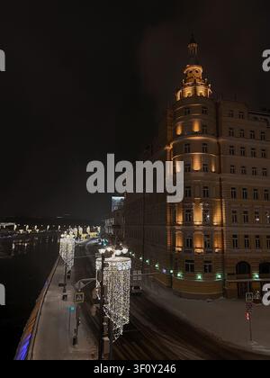 Moskau, Russland - 22. Januar 2022: Historisches beleuchtetes Gebäude und festliche Straßenlaternen entlang der Moskauer Uferpromenade bei Nacht Stockfoto
