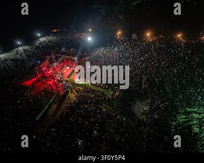 Luftbild einer großen Menschenmenge, die sich bei einem Nachtkonzert mit hellem Bühnenlicht versammelt hat, das das Publikum in Port Harcourt, Bundesstaat Rivers, Nigeria, beleuchtet. Stockfoto