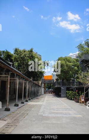TAIPEI, TAIWAN – 15. FEBRUAR 2022: Hochwinkelaufnahme eines Touristen, der einen sonnigen Weg zwischen historischen Gebäuden und einem Säulengang hinuntergeht Stockfoto