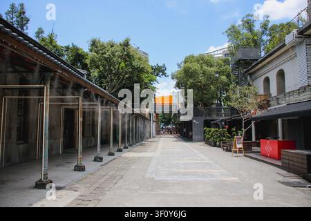 TAIPEI, TAIWAN – 15. FEBRUAR 2022: Hochwinkelaufnahme eines Touristen, der einen sonnigen Weg zwischen historischen Gebäuden und einem Säulengang hinuntergeht Stockfoto