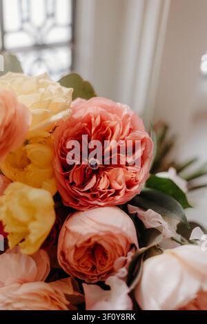 Verlobungsring, der in einem üppigen Rosenstrauß ruht Stockfoto