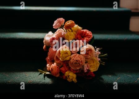 Dramatisches Licht trifft auf einen Blumenstrauß auf dunklen Treppen Stockfoto