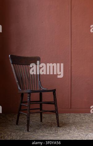 Vintage-Stuhl aus dunklem Holz in einem leeren Raum Stockfoto