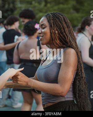 Glückliche schwarze Frau lächelt beim Partner-Tanz Stockfoto
