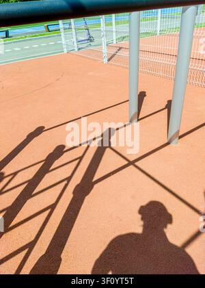Schatten auf orangefarbenem Boden in einer Spielplatzumgebung Stockfoto