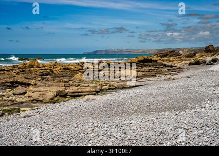 Blick nach Norden in Richtung Bude von den Felsen am Strand von Millook Haven, Cornwall, UK Stockfoto