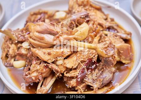 Authentisches Cheongsong-Gehärtet-Gehühn mit Knoblauch- und Sojaglasur, umgeben von traditionellen Beilagen, die die regionale asiatische Kulturgastronomie hervorheben Stockfoto