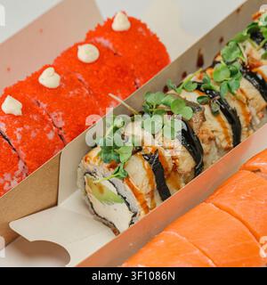 Ein paar Kisten gefüllt mit verschiedenen Arten von Sushi, einschließlich Rolls und Sashimi, die eine köstliche Auswahl an Meeresfrüchten und Aromen präsentieren. Stockfoto