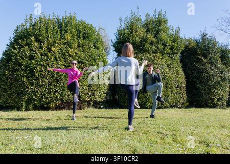 Vollständige Ansicht von drei Freunden, die zusammen im Park trainieren Stockfoto