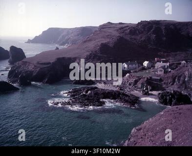 Kynance Cove, auf der Lizard-Halbinsel, wurde in der frühen viktorianischen Ära populär, mit vielen namhaften Besuchern, darunter Königin Victoria und der Dichter Alfred Tennyson. Die BBC hat Kynance Cove als „eines der schönsten Küstenstreifen im Südwesten“ beschrieben. Der South West Coast Path verläuft an den Klippen vorbei, die die Bucht überblicken. Stockfoto