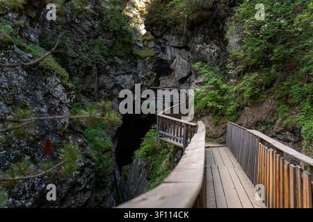 Holzsteg, der dem Gorner Gorge Canyon-Pfad mit Felswänden folgt Stockfoto