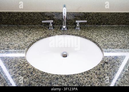 Waschbecken mit Marmorplatte und eingebautem Wasserhahn. Stockfoto