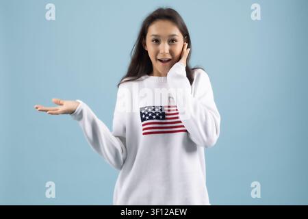 Schockierte junge Frau in einem Hemd mit amerikanischer Flagge, die überrascht schreit Stockfoto