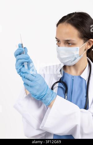 Medizinischer Mitarbeiter hält eine Spritze und bereitet sich auf den Impfprozess vor Stockfoto
