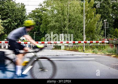 Radfahrer vor geschlossener Schranke 07.07.2026: Ein Radfahrer fährt vor einem geschlossenen Bahnübergang am Bahnhof Buchschlag in Dreieich vorbei. Symbolbild für Radverkehr, Schienenverkehr, Mobilität und Verkehrswende. Dreieich Buchschlag Hessen Deutschland *** Cyclist in Front of a Closed Barrier July 7, 2026 A cyclist rides past a closed railroad crossing at the Buchschlag train station in Dreieich. Symbolic image representing cycling, rail transport, mobility, and the transportation transition. Dreieich, Buchschlag, Hesse, Germany Stockfoto