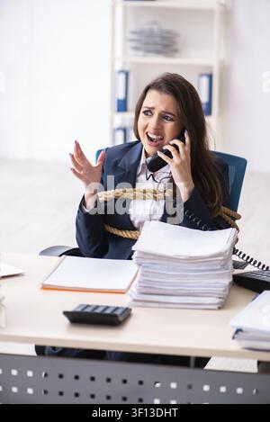 Junge schöne Mitarbeiter gebunden mit Seil im Büro Stockfoto