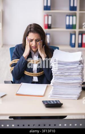 Junge schöne Mitarbeiter gebunden mit Seil im Büro Stockfoto