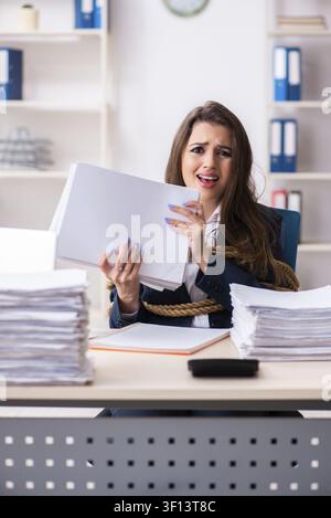 Junge schöne Mitarbeiter gebunden mit Seil im Büro Stockfoto