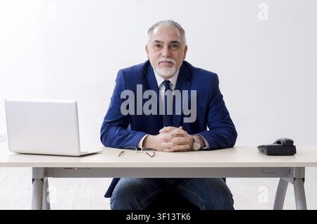 Alter Geschäftsmann Yoga Übungen im Büro Stockfoto