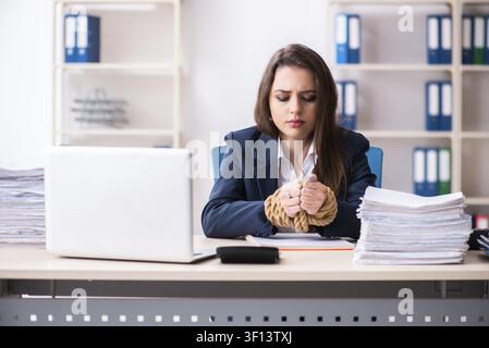 Junge schöne Mitarbeiter gebunden mit Seil im Büro Stockfoto