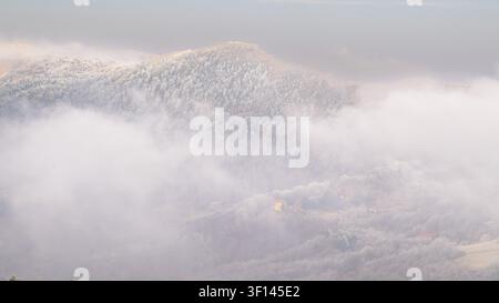 Neblige Aussicht auf Hügel und Berge unter einer nebligen Decke, Italien Stockfoto