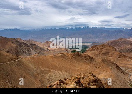 Eine sich windende Asphaltstraße schlängelt sich durch die trockenen und felsigen Hügel von Ladakh, Indien, und öffnet sich zu einem weiten Panoramablick über das Indus-Tal und in die Ferne Stockfoto
