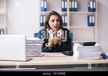 Junge schöne Mitarbeiter gebunden mit Seil im Büro Stockfoto