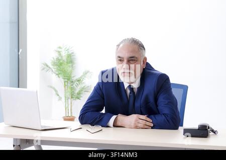 Alter Geschäftsmann Yoga Übungen im Büro Stockfoto