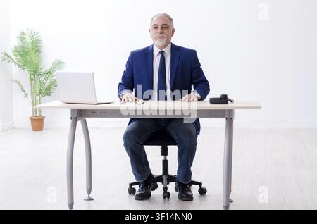Alter Geschäftsmann Yoga Übungen im Büro Stockfoto