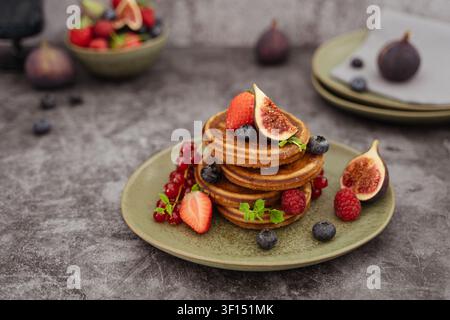 Frühstücksturm aus hausgemachten Pancake-Waffeln, garniert mit frischen Beeren und Feigen Stockfoto