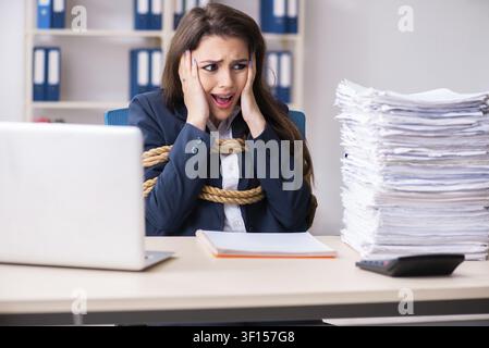 Junge schöne Mitarbeiter gebunden mit Seil im Büro Stockfoto