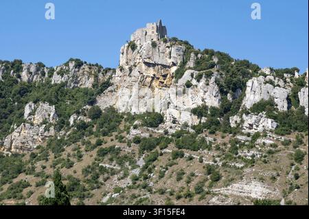 Majestätische Ruine des mittelalterlichen Schlosses Chateau de Crussol, das auf einem steilen Kalksteinfelsen über dem Tal thront, vor einem hellblauen Himmel im Sonnenlicht, Saint-Pe Stockfoto