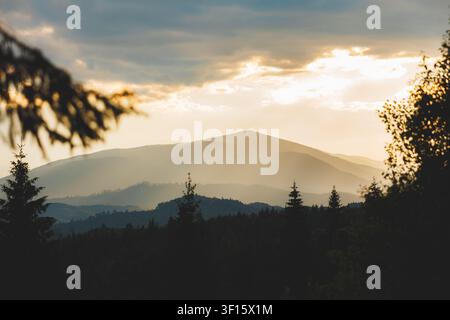 Goldene Stunde über den Karpaten mit Sonnenstrahlen, die durch die Wolken brechen. Hochwertiges Foto Stockfoto