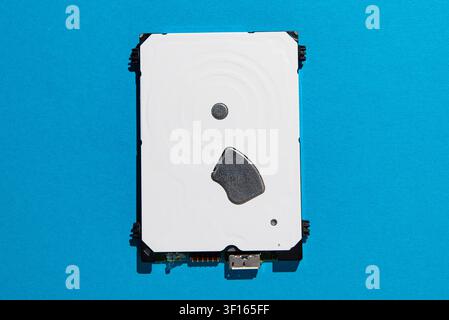 Top-Down-Studioaufnahme einer internen Festplatte, isoliert auf einem hellblauen Hintergrund, die Computerspeicher, Datensicherung und Hardware-Technologie repräsentiert Stockfoto