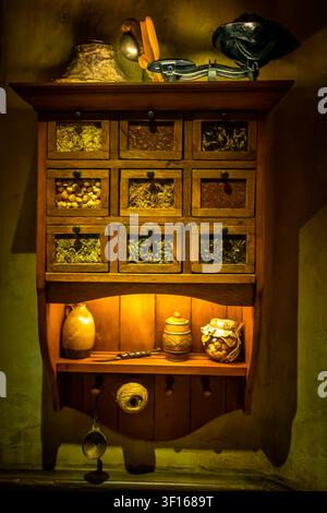 Ein antiker hölzerner Apotheken-Schrank gefüllt mit getrockneten Kräutern und Gewürzen, ausgestellt am Hobbiton-Filmset in Matamata, Neuseeland. Stockfoto